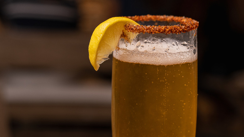 Beer glass with lemon wedge and chili salt on rim