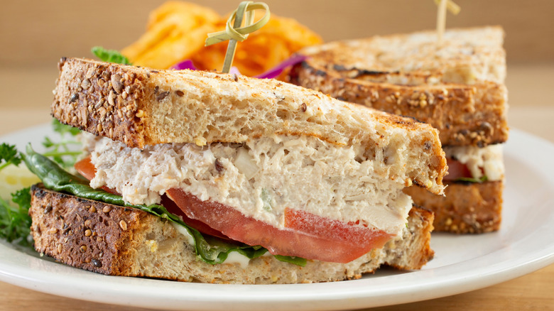 Tuna salad sandwich with lettuce and tomato on a plate