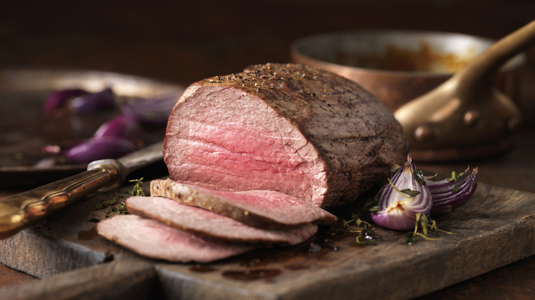 A beef roast sits on a carving board