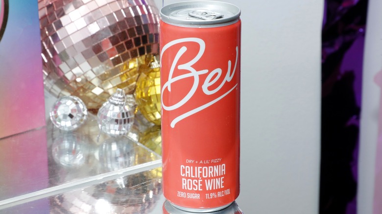 Can of Bev rosé wine with ornaments and disco ball in background